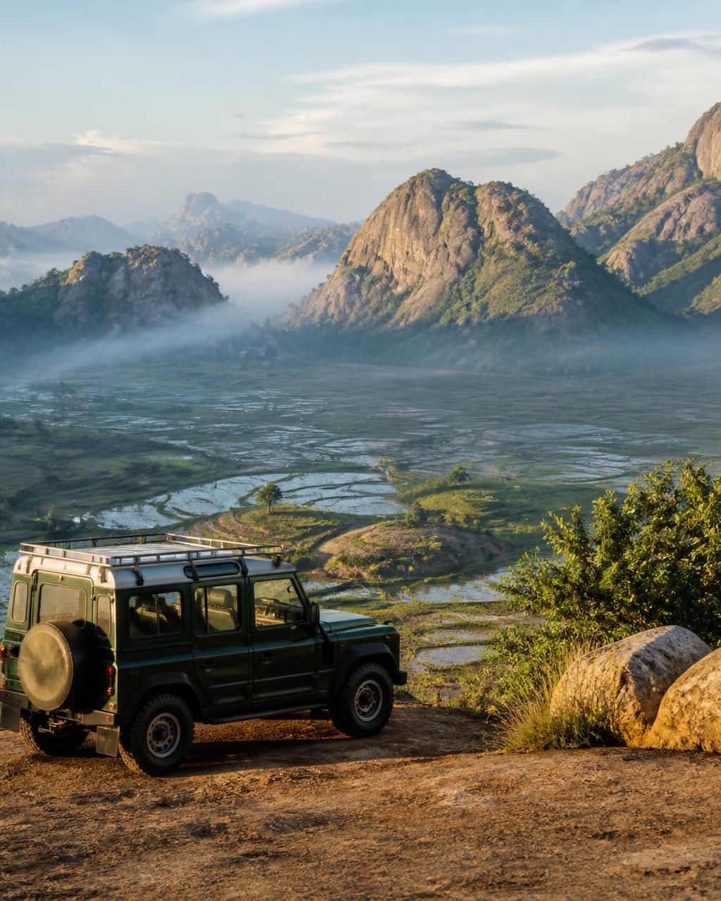 4×4 parked at a highland viewpoint over Madagascar's rice terraces at sunrise